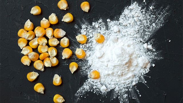 Corn starch and kernels on a black background