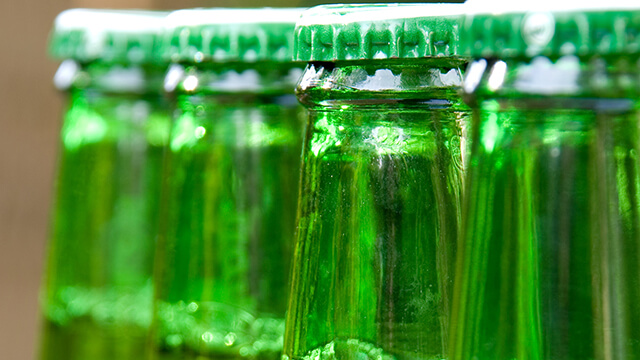Row of green beer bottles unopened smaller